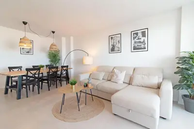 a living room with a couch and a table at Global Vacacional, Moderno apartamento de dos terrazas con vistas al mar y a la montaña in Canet de Berenguer