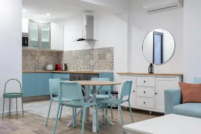 a kitchen and living room with a blue couch and a table at ApartUP Ruzafa Vertical in Valencia
