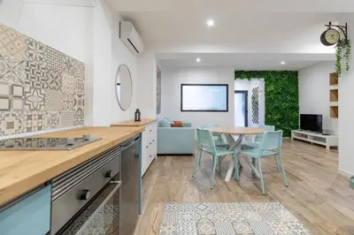 a kitchen with blue cabinets and a tile wall at ApartUP Ruzafa Vertical in Valencia