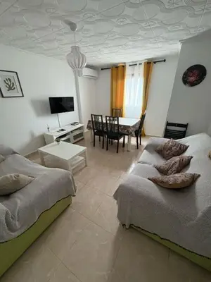 a living room with two beds and a dining room at Appartement Célia in Algemesí