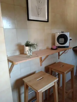 a kitchen with wooden tables and a microwave on a wall at La Casica in Chulilla