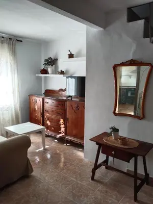 a living room with a wooden dresser and a mirror at La Casica in Chulilla