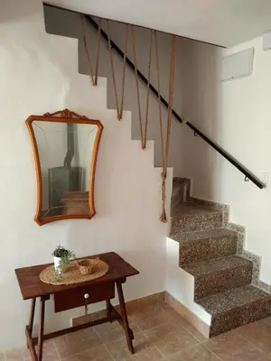 a mirror on a wall next to a table and stairs at La Casica in Chulilla