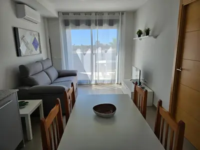 a living room with a table and a couch at Realrent Neo Mediterráneo in Barrio-Mar