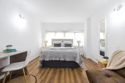 a white bedroom with a bed and a desk at FLORIT FLATS - The Apolo Studio in Valencia