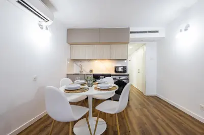 a kitchen and dining room with a white table and chairs at FLORIT FLATS - The Apolo Studio in Valencia