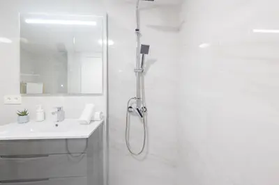a white bathroom with a shower and a sink at FLORIT FLATS - The Apolo Studio in Valencia