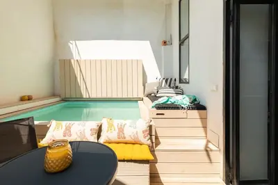 a room with a pool with a table and chairs at cozy loft patio+pool +wifi in Valencia