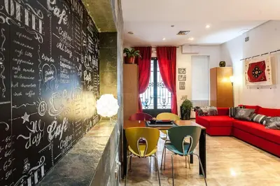 a living room with a red couch and a black wall at Pequeño Loft en Ruzafa wifi in Valencia