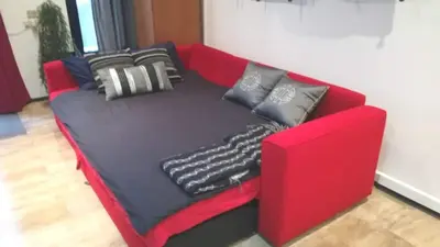 a red couch with pillows on top of it at Pequeño Loft en Ruzafa wifi in Valencia