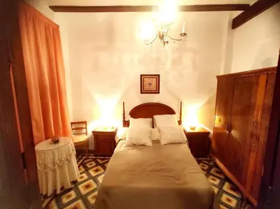 a bedroom with a bed and a chandelier at Encantadora casa de pueblo in Sagunto