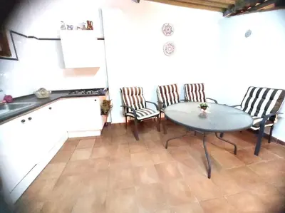 a kitchen with a table and chairs in a room at Encantadora casa de pueblo in Sagunto