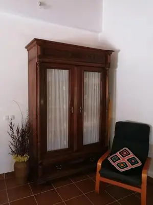 a wooden cabinet and a chair in a room at Casa La Higuera in Chulilla
