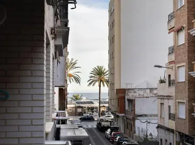 a city street with buildings and palm trees and the ocean at Adorable apartment 60m from the beach by Hometels in Puerto de Sagunto