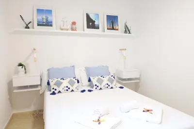 a bedroom with a white bed with blue and white pillows at Adorable apartment 60m from the beach by Hometels in Puerto de Sagunto