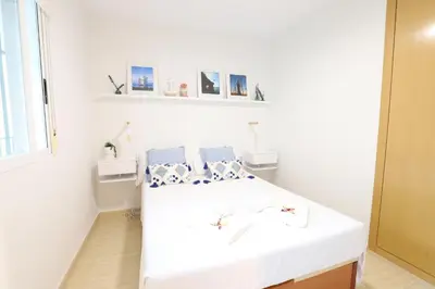 a white room with a bed with two pillows at Adorable apartment 60m from the beach by Hometels in Puerto de Sagunto