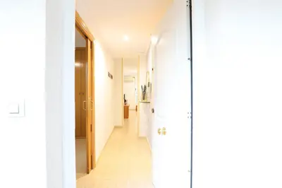 a hallway of a house with white walls and wooden floors at Adorable apartment 60m from the beach by Hometels in Puerto de Sagunto