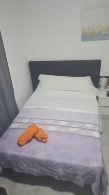 a bed with a pair of orange slippers on it at MHrosa in Valencia