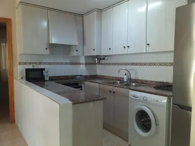 a kitchen with white cabinets and a washing machine at Playa Paradís - Primera linea de playa - AP-7 3min - Self check-in 24h in Moncófar