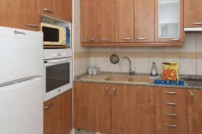 a kitchen with wooden cabinets and a white refrigerator at Prado, A-5-52 PK INT 85 in Cullera