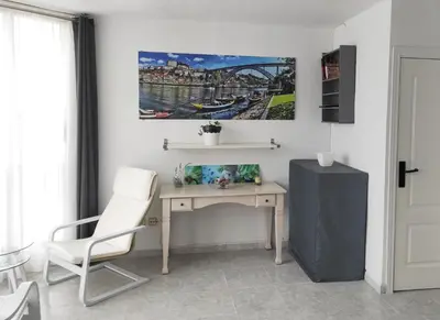 a desk with a white chair and a picture on the wall at Terrace & Sea Views in Cullera in Faro de Cullera