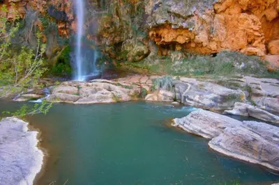 a waterfall and a pool of water with rocks at Precioso apartamento en altura in Altura