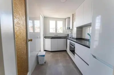 a kitchen with white cabinets and a counter top at Precioso apartamento en altura in Altura