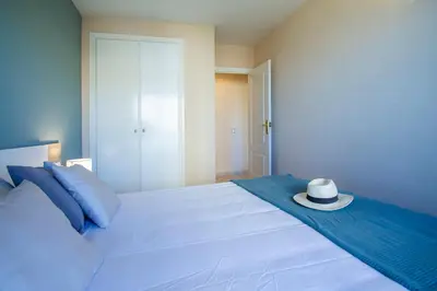 a white bed with a hat on top of it at ESPACIO 5 - Primera Línea de Playa in Cullera
