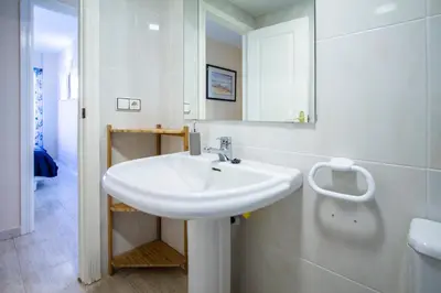 a white bathroom with a sink and a mirror at ESPACIO 5 - Primera Línea de Playa in Cullera