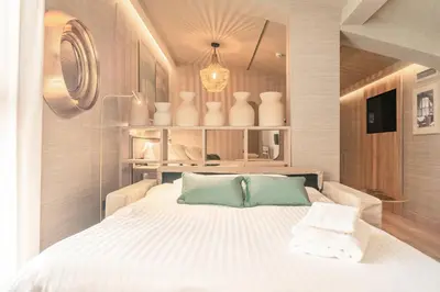 a bedroom with a bed with white sheets and vases at The Valentia Corretgería in Valencia
