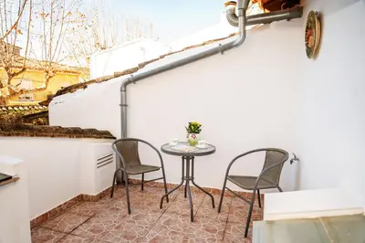 a small table and chairs on the balcony of a building at Casa rural la balsa in Anna