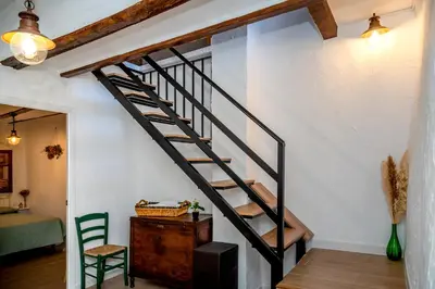 a staircase in a room with a table and a chair at Casa rural la balsa in Anna