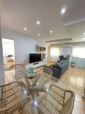 a living room with a glass table and chairs at UIM Mediterraneo Virgen del Carmen 1 Wifi in Puerto de Sagunto