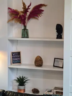 a shelf with a vase with a plant on it at Hlius Brand New Apartments in Valencia