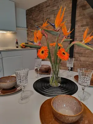 a vase filled with orange flowers on a kitchen counter at Hlius Brand New Apartments in Valencia