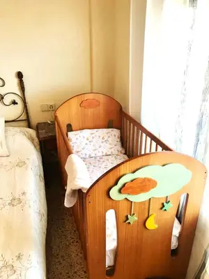 a bedroom with a wooden crib with a bird painted on it at Spacious apartment in Tavernes de la Valldigna with sea view in El Brosquil