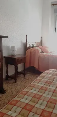 a bedroom with a bed and a table with a lamp at Spacious apartment in Tavernes de la Valldigna with sea view in El Brosquil