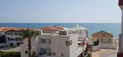 a building with the number on it next to the ocean at Spacious apartment in Tavernes de la Valldigna with sea view in El Brosquil