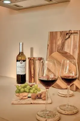 two glasses of wine on a table with a bottle of wine at Suite con Jacuzzi en la montaña. in Llombay