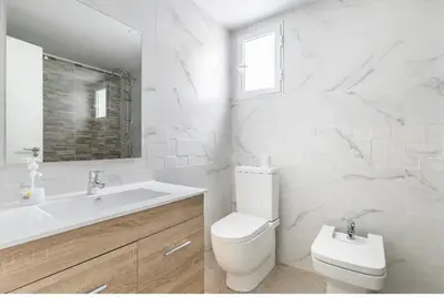 a white bathroom with a toilet and a sink at private room in shared apartment Valencia WorkStay in Valencia