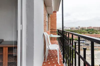 a white chair sitting on a balcony with a table at private room in shared apartment Valencia WorkStay in Valencia