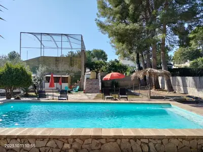 a pool with chairs and umbrellas in a yard at Casa Mas Montanas vakantiehuis met zwembad Max 10-12 pers Vlakbij Valencia in Godelleta