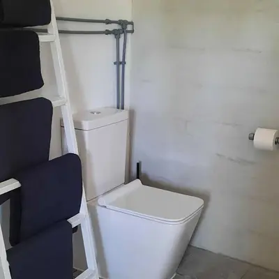 a bathroom with a white toilet and a ladder at Casa Mas Montanas vakantiehuis met zwembad Max 10-12 pers Vlakbij Valencia in Godelleta