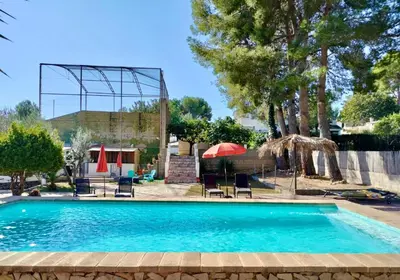 a swimming pool with chairs and umbrellas in a yard at Casa Mas Montanas vakantiehuis met zwembad Max 10-12 pers Vlakbij Valencia in Godelleta