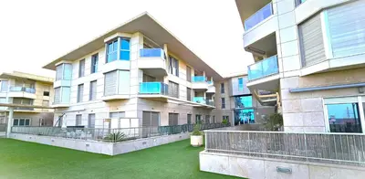 an apartment building with green grass in front of it at BEACH VALENCIA LUXURY B40-7 Apartament on Beach in Valencia
