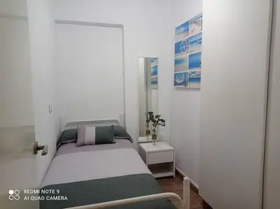 a small bedroom with a bed and a table at Apartamento playa in Playa Pobla de Farnals