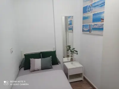 a bedroom with a bed with green and white pillows at Apartamento playa in Playa Pobla de Farnals