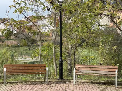 two park benches sitting next to a light pole at Casa Rural El Rincón de Beatriz in Ayódar