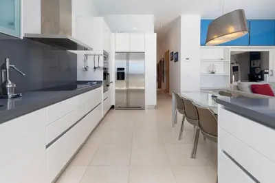 a kitchen with white cabinets and a stainless steel refrigerator at luxury sea view apartment with 2 rooms in Valencia