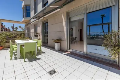 a patio with a table and chairs on a balcony at luxury sea view apartment with 2 rooms in Valencia